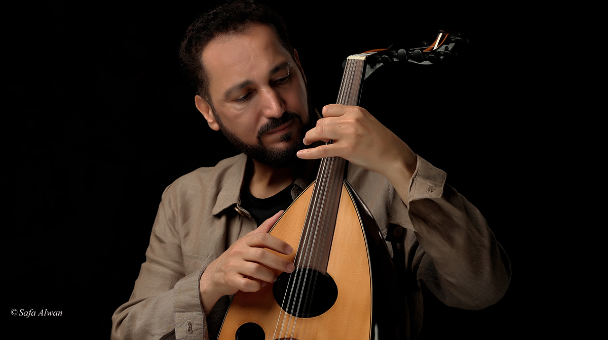 Naseer Shamma plays the oud against a black backdrop.